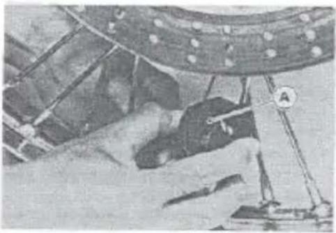 Close-up of a person working on machinery with a circular component and mechanical structure (no visible text or symbols)