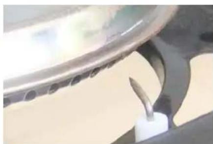 Close-up of a kitchen utensil with a metal tool inserted, showing no visible text or symbols