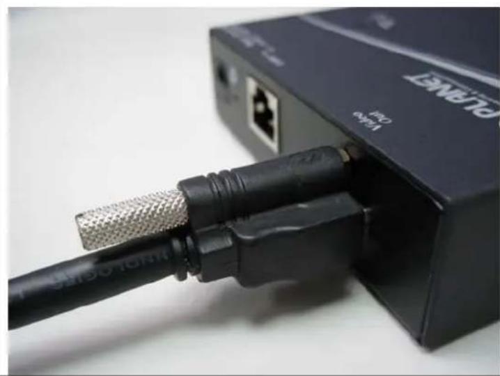 Close-up of a black USB cable connector with metallic connector, mounted on a network switch (no visible text or symbols)