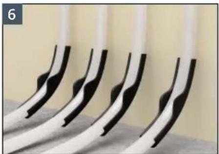 Close-up of five black and white curved objects arranged in a row, no visible text or symbols.