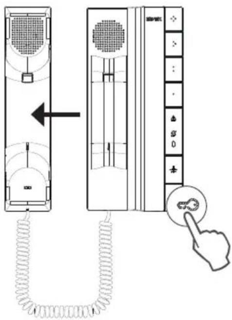 Diagram showing a hand pressing a button on a wall-mounted device, with labeled components and directional arrow indicating movement.