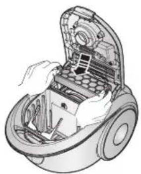 Illustration of hands assembling a vacuum cleaner into a housing (no text or symbols visible)