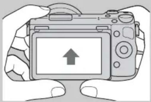 Illustration of hands holding a DSLR camera with an upward arrow on the screen (no text or symbols)