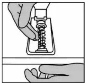Illustration of a hand holding a spring-loaded mechanical component, showing internal structure and assembly.