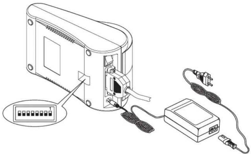 Line drawing of an electronic device with labeled ports and wiring, showing internal components connected to a power outlet (no text or symbols present)