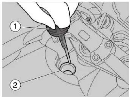 Technical diagram showing a hand using a tool to inspect or repair mechanical components, labeled with parts 1 and 2.