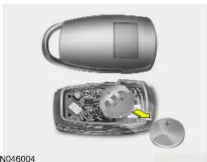 Interior view of a device showing an open lid, internal circuit board, and a disc with a yellow arrow (no text or symbols visible)