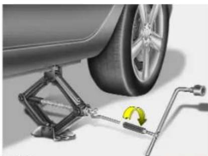 Mechanical assembly diagram showing a car wheel connected to a spring scale with a yellow-green arrow indicating rotation (no text or symbols present)