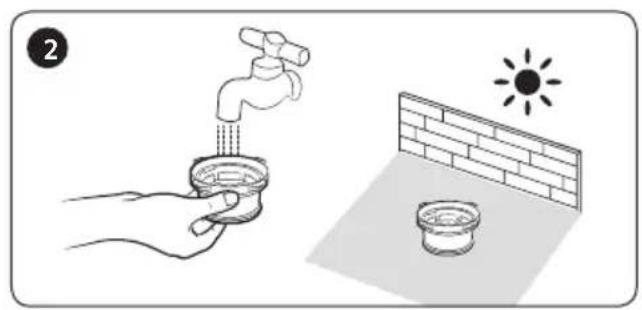 Illustration showing a hand washing a faucet with a sun symbol above its surface, next to a brick wall and a small bowl (no text or symbols)