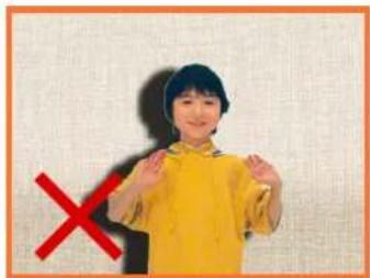 Child in yellow shirt making a 'X' sign with red X symbol, likely indicating cancellation or rejection