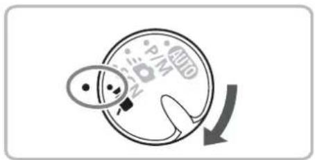 Diagram showing a hand holding a circular object with labeled pins and a curved arrow indicating rotation or movement.