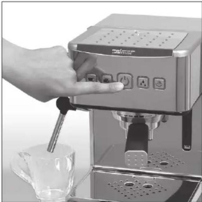 Close-up of a hand using a Elmer espresso machine to press or pour it, with a glass cup and water bottle nearby (no visible text or symbols)