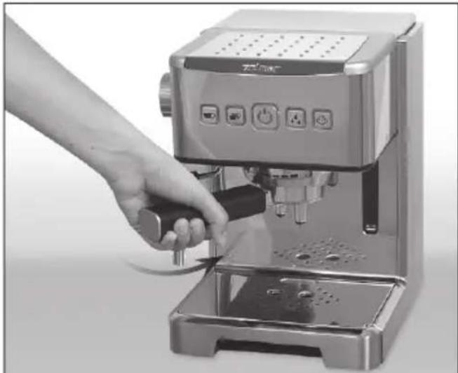 Hand using a standard espresso machine to press or adjust its surface (no visible text or symbols)