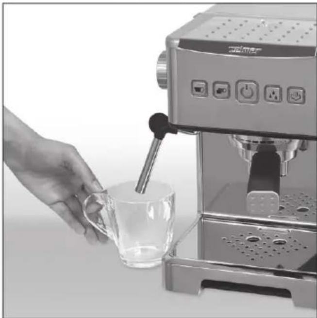 Close-up of a hand pouring liquid into a glass mug using a espresso machine (no visible text or symbols)