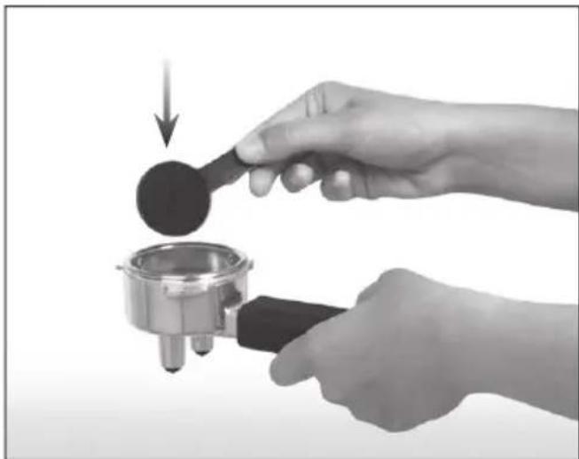 Close-up of hands using a mechanical tool to press or adjust a dark circular component, with no visible text or symbols.