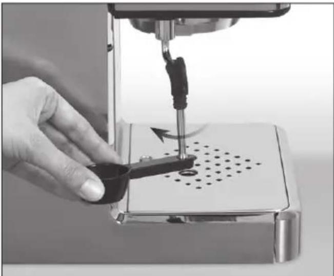 Close-up of a hand using a sewing machine to press or adjust a small mechanical component on a perforated base (no visible text or symbols)