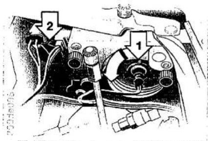 Technical diagram of a mechanical device with labeled parts 1 and 2, likely for assembly or maintenance instructions.