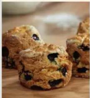 Close-up of three buns of dark blue cookies on a wooden surface (no text or symbols visible)