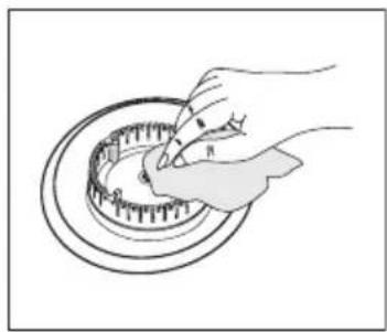 Illustration of a hand using a tool to cut a circular mechanical component (no text or symbols visible)