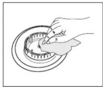 Illustration of a hand using a tool to adjust or install a circular component (no text or symbols visible)