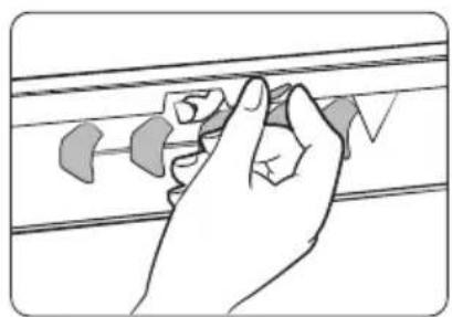 Hand holding a small object over a horizontal line, no text or symbols visible