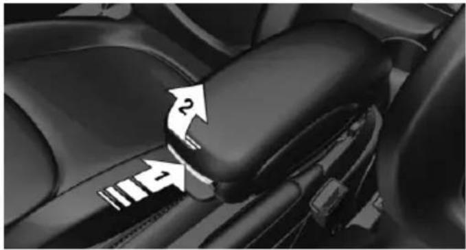 Close-up of a car's seatbelt mechanism with directional arrows indicating rotation (no text or symbols)