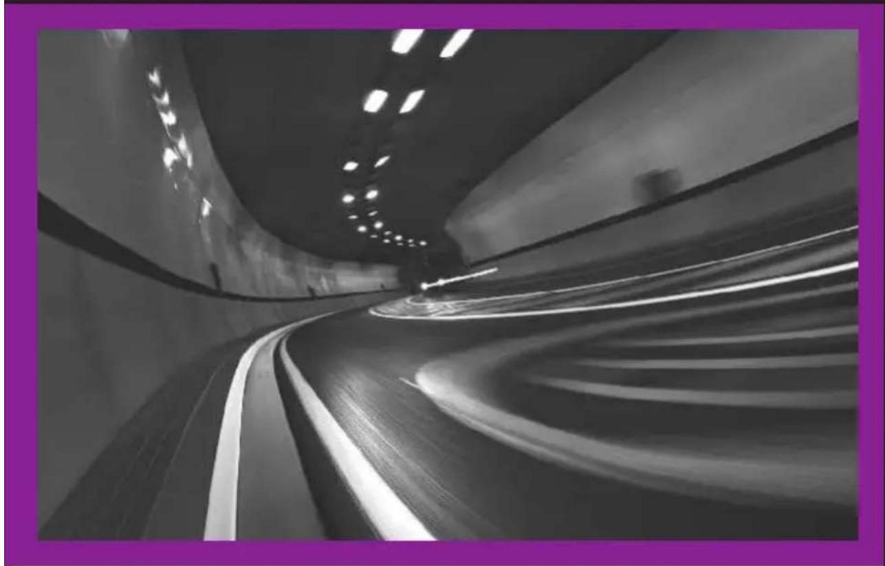 Black and white photo of a curved highway with motion blur, framed by a purple border (no text or symbols visible)