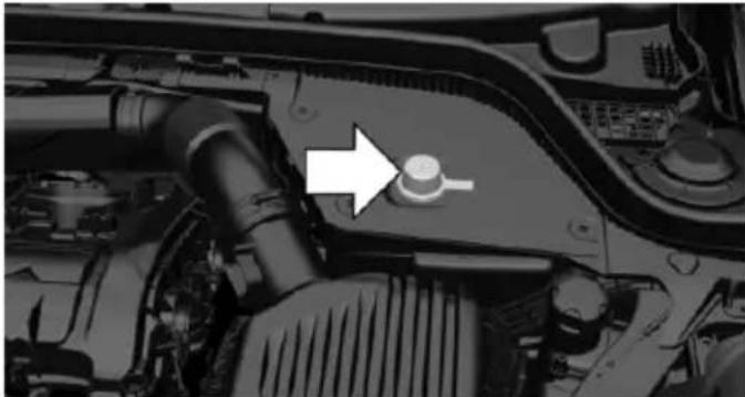 Close-up of a car engine bay with a white arrow pointing to a component (no visible text or symbols)