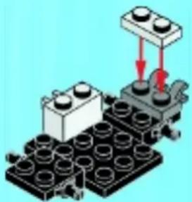 Diagram of a robotic arm assembling a LEGO base with a block on top (no text or symbols)