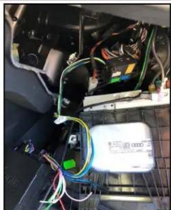 Interior view of a vehicle's internal electronics panel with wiring and a battery pack (no visible text or symbols)