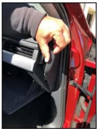 Close-up of a hand adjusting a red car door panel, no visible text or symbols