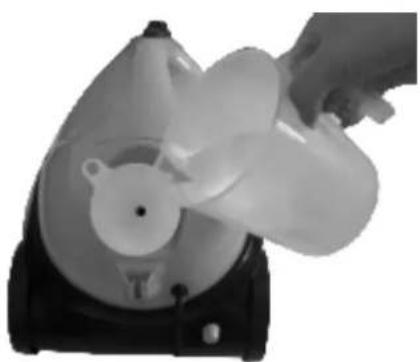 Hand pouring liquid into a plastic fan device (no text or symbols visible)