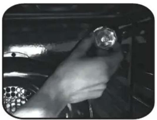 Close-up of a hand holding a small metallic object inside a vehicle or engine compartment (no visible text or symbols)