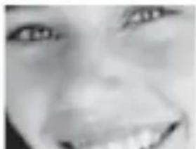 Close-up grayscale photo of a human face with visible teeth and mouth (no text or symbols)