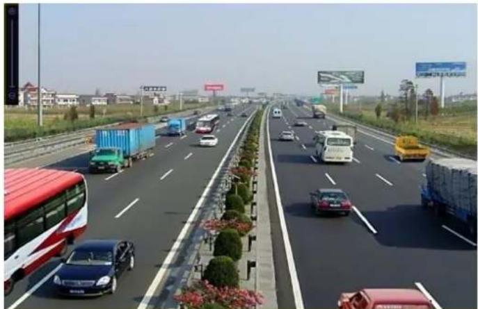 Highway traffic scene with multiple vehicles and trucks, no visible text or signage