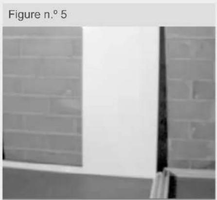 Exterior view of a brick wall with a vertical window and partial corner detail (no signage or text)