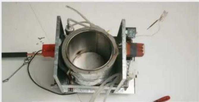 Metallic mechanical component with wiring and red connectors, no visible text or symbols