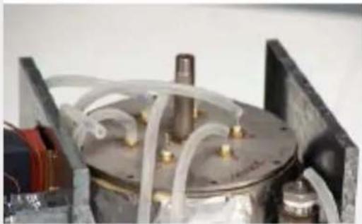 Close-up of a mechanical device with transparent tubing and a central cylindrical component (no visible text or symbols)