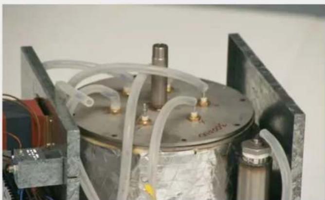Close-up of a mechanical device with transparent tubing and a metallic casing (no visible text or symbols)