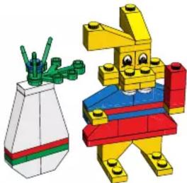 3D model of a yellow and blue LEGO robot holding a green arm, next to a white container (no text or symbols)
