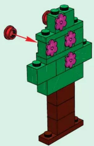 3D diagram of a green LEGO structure with purple flower-like elements and a red arrow pointing to a small circular component (no text or symbols)