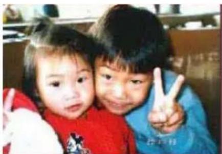 Two children making peace signs together (no visible text or symbols)
