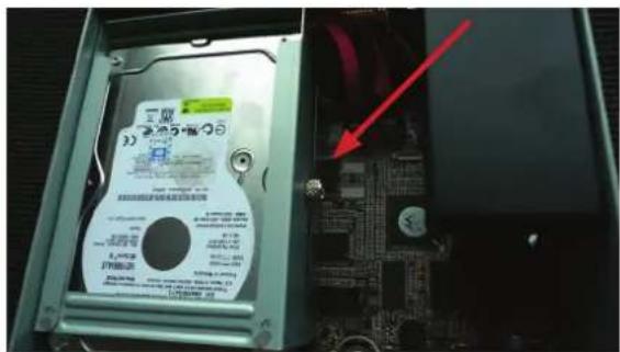 Photo of a hard disk drive with visible label and red arrow pointing to a component, showing internal circuit board and hardware casing.