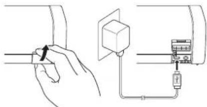 Diagram showing hand holding a small component connected to an electrical outlet with labeled components