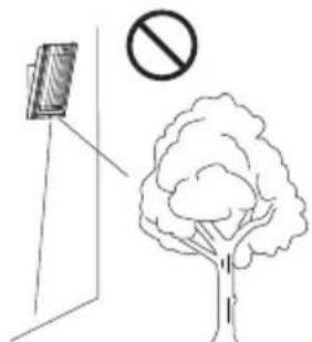 Safety warning illustration showing a device above a tree with a prohibition symbol