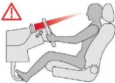 Safety warning illustration showing a person using a device to drive a car, with a red warning symbol and warning triangle.
