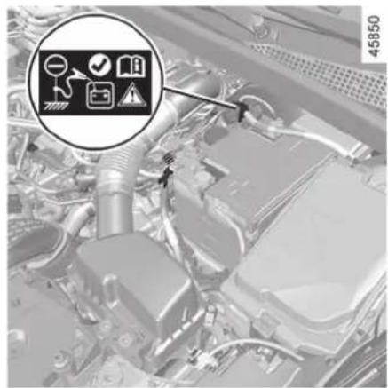 Technical diagram of an engine bay with labeled icons and a magnified circular detail showing road, switch, and warning symbols.