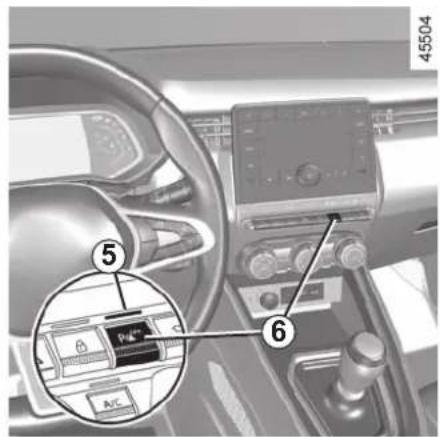 Car interior photo with numbered annotations pointing to a device panel and control panel, showing a vehicle's dashboard and steering wheel.
