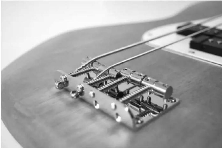 Close-up of an electric guitar fretboard with visible mechanical components (no text or symbols)