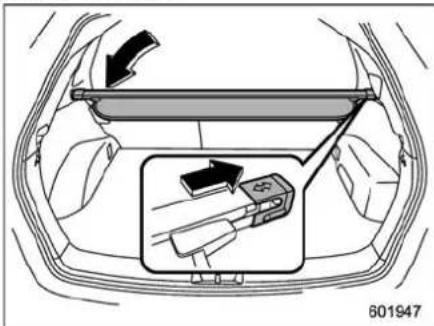 Diagram showing car interior with a hand panel and directional arrow, highlighting a device component in the lower section.